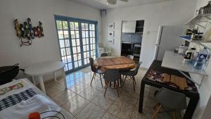 a kitchen with a table and chairs in a room at Linda casa para temporada - Familia Munhoz Ventura in Cananéia