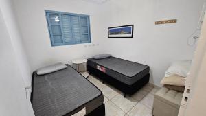 a room with two beds and a window at Linda casa para temporada - Familia Munhoz Ventura in Cananéia