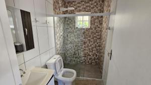 a bathroom with a shower and a toilet and a sink at Linda casa para temporada - Familia Munhoz Ventura in Cananéia