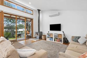 un soggiorno con divano e TV a schermo piatto di Jan Juc Coastal Retreat 500m to Beach Pet Friendly a Torquay