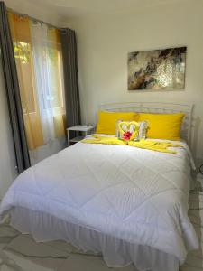 a bedroom with a white bed with a yellow headboard at Agape Suites-Room 1- Ground Floor in Soufrière