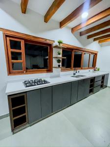a kitchen with a counter with a sink and windows at Villa Ancestral in Villa de Leyva +22 photos