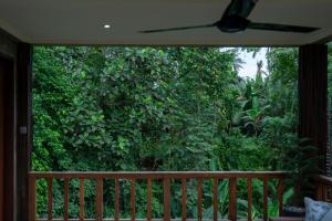 a screened in porch with a large green bush at Elforest 3 in Payangan +2 photos