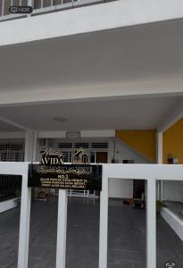a white fence in front of a building at Avida Homestay in Kampong Jelatang