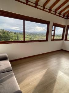 an empty room with a couch and large windows at Villa Ancestral in Villa de Leyva