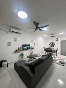 a living room with a couch and a tv at Avida Homestay in Kampong Jelatang