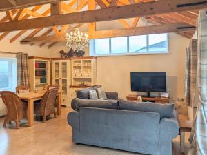 ein Wohnzimmer mit einem Sofa und einem Tisch mit einem TV in der Unterkunft The Old Foundry Holiday Cottage in Burgh le Marsh