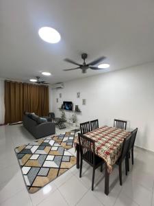 a living room with a table and chairs and a couch at Avida Homestay in Kampong Jelatang