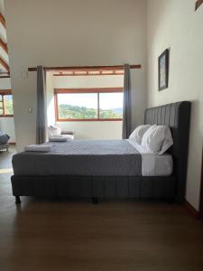 a bedroom with a large bed with a window at Villa Ancestral in Villa de Leyva