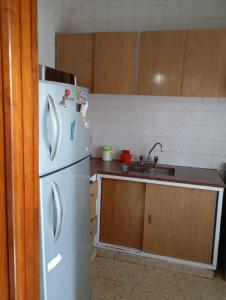 a kitchen with a white refrigerator and a sink at Departamento San Bernardo - 4 Ambientes - Cochera - Parrilla in San Bernardo