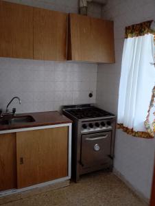 a small kitchen with a stove and a sink at Departamento San Bernardo - 4 Ambientes - Cochera - Parrilla in San Bernardo