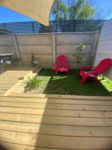 two red chairs and a table in a backyard at Cabaña moderna con piscina y excelente ubicación en Casablanca in Casablanca +5 photos