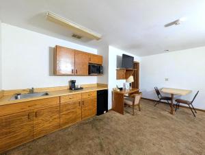 a kitchen with a sink and a table with chairs at Cool City Motel in Two Rivers