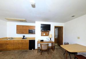 a kitchen with a sink and a table with chairs at Cool City Motel in Two Rivers