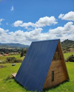 a house with a blue roof in a field at La Alejandría de Guasca in Guasca +18 photos