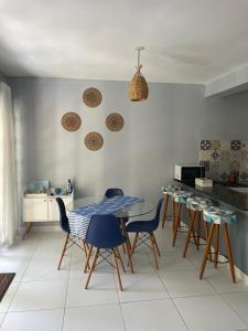 eine Küche mit einem Tisch und Stühlen in einer Küche in der Unterkunft Casa aconchegante em condomínio arborizado in Pipa