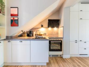 a kitchen with white cabinets and an oven at Wening-Hüs Wening-Hüs , in Boldixum