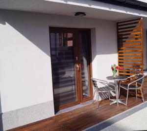a patio with a table and chairs and a door at Pensjonat Sunrise in Rewal