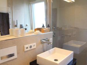 ein Badezimmer mit einem weißen Waschbecken und einem Spiegel in der Unterkunft Holiday apartment with 1 bedroom in Murnau am Staffelsee + 22 Fotos