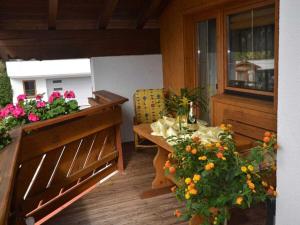 a patio with a table and flowers on a balcony at Holiday apartment with 2 bedrooms in Fulpmes
