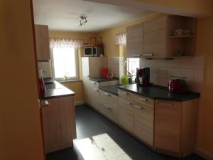 eine kleine Küche mit Holzschränken und einem Fenster in der Unterkunft 2 in the holiday home Am Waldweg in Arnoldshammer