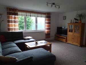 ein Wohnzimmer mit einer Couch und einem Couchtisch in der Unterkunft 2 in the holiday home Am Waldweg in Arnoldshammer