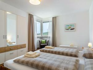 a bedroom with two beds and a chair in it at Holiday apartment with 1 bedroom in Meersburg