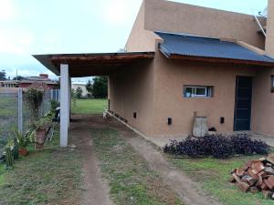 ビージャ・アニサカテにあるCasa Barrancas del Río Anisacateのガレージ付きの家の横からの眺め +2枚の写真