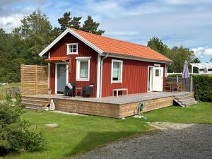 a red house with a wooden deck in a yard at 6 person holiday home in SVANESUND in Buvik