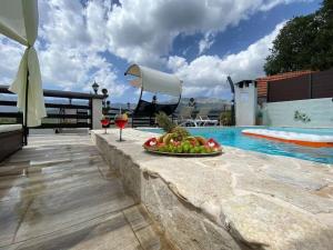 a bowl of fruit on a table next to a swimming pool at Villa in Zagvozd with swimming pool in Vranješi