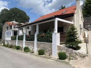 a white house with a red roof at Villa in Zagvozd with swimming pool in Vranješi
