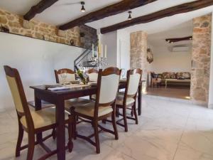 a dining room with a table and chairs at Villa in Zagvozd with swimming pool in Vranješi