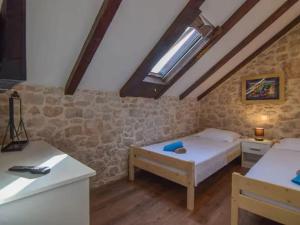 a bedroom with a bed and a table in a room at Villa in Zagvozd with swimming pool in Vranješi +36 photos
