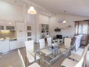 a dining room and kitchen with a glass table and chairs at Cecilia with pool in Nenadići