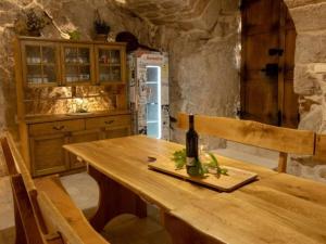 een keuken met een houten tafel en een fles wijn bij Villa in Zavojane with swimming pool in Vodenjak