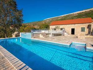 een groot blauw zwembad voor een gebouw bij Villa in Zavojane with swimming pool in Vodenjak