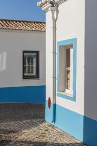 a blue and white building with a window at NAU Salema Beach Village in Salema