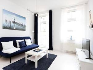 a living room with a blue couch and a table at Residence at the Spa Park 2 in Warnemünde