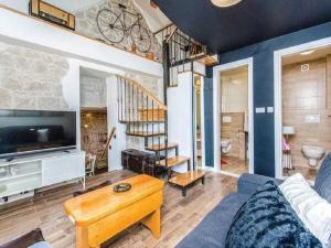 een woonkamer met een bank, een tv en een trap bij Villa in Zagvozd with swimming pool in Šarići