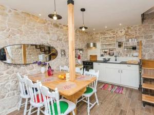 een keuken en eetkamer met een houten tafel en stoelen bij Villa in Zagvozd with swimming pool in Šarići