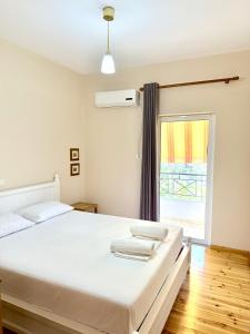 a bedroom with a white bed and a window at Janakis Apartments in Himare
