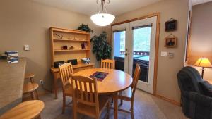 eine Küche und ein Esszimmer mit Tisch und Stühlen in der Unterkunft Crystal Forest #11 By Bear Country in Sun Peaks