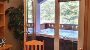 einen Whirlpool in einem Zimmer mit Fenster in der Unterkunft Crystal Forest #11 By Bear Country in Sun Peaks