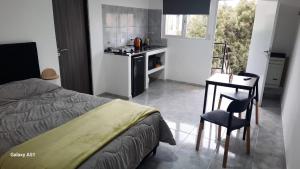 a bedroom with a bed and a table and a chair at Rada Tilly Apart 2 Unidad 6 in Rada Tilly