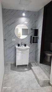 a bathroom with a white sink and a mirror at Rada Tilly Apart 2 Unidad 6 in Rada Tilly +4 photos