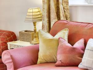a pink couch with pillows and a lamp on a table at Carriage House - E5119 in West Burton