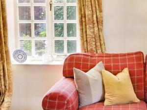 a red couch with pillows in front of a window at Carriage House - E5119 in West Burton +28 photos