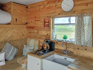 een keuken met een wastafel en een klok aan de muur bij The Box - Oasis Farm in Fareham