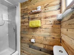 a bathroom with a wooden wall at The Box - Oasis Farm in Fareham +4 photos