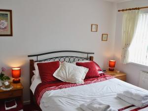 a bedroom with a bed with red and white pillows at Sweet Briar in Newquay